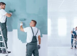 Men painting empty home interior