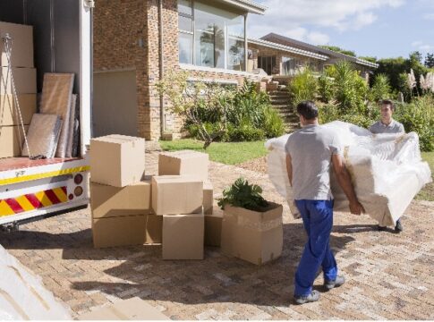 Movers carrying sofa from moving van to house